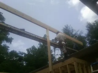 Carpenter setting a ridge beam over a new addition frame — Ice Dam Removal by Roofing Brothers in Canal Winchester