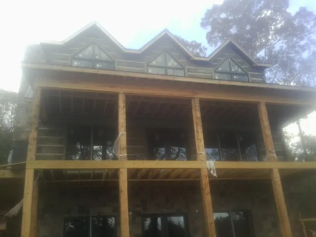 Dormers and porch framing on a large log home under construction — Roof Coating work by our crew in Canal Winchester