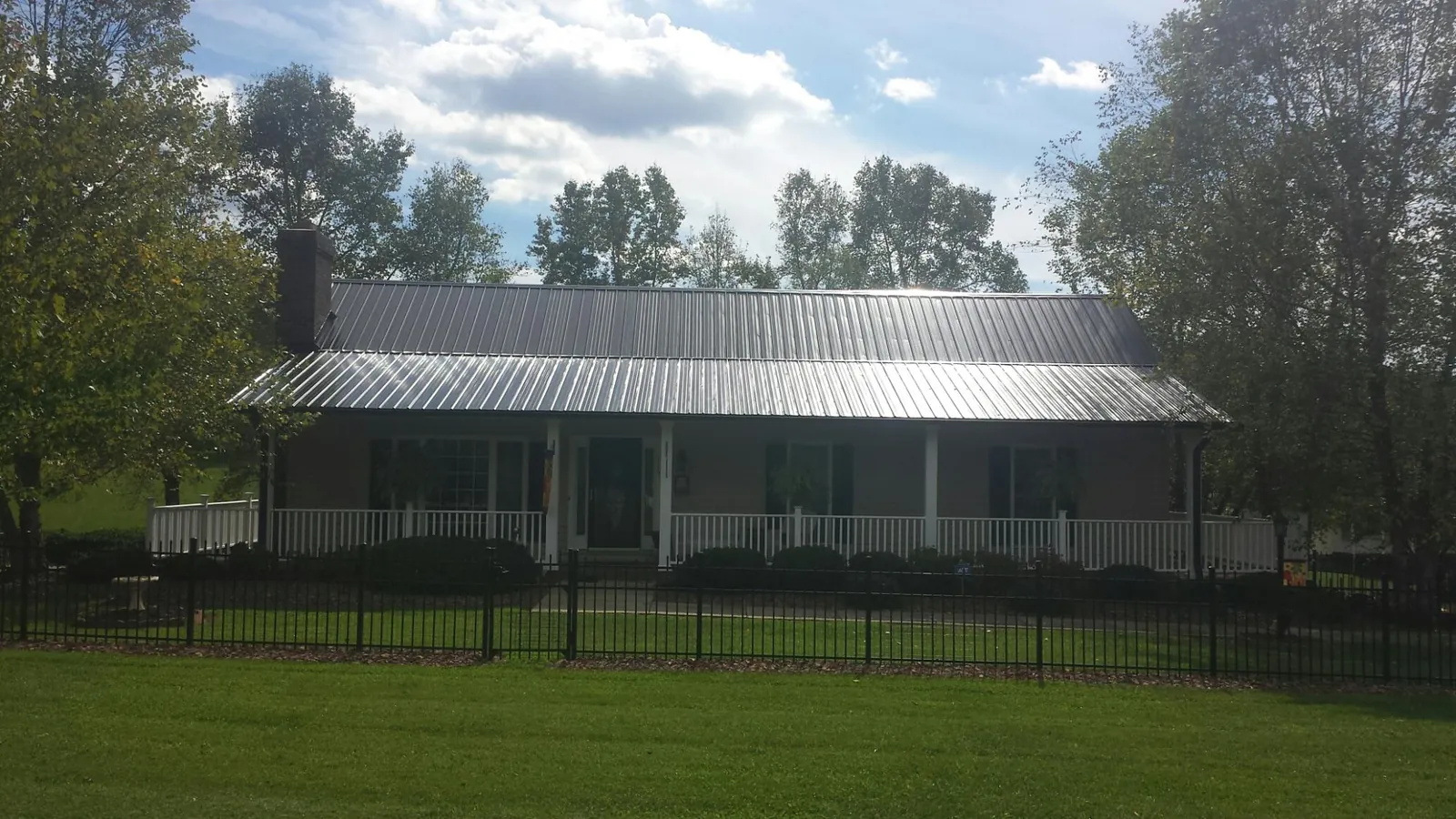 Gray metal roof on a brick ranch with a full width front porch — Gutter Guard Installation work by our crew in Canal Winchester