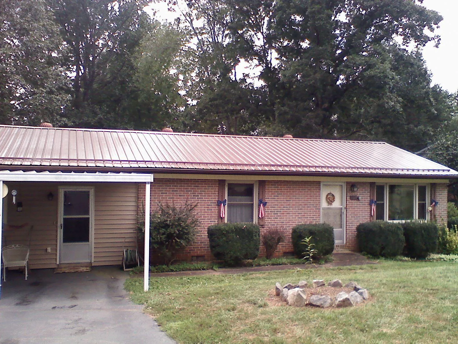 Bronze metal roof and carport on a brick ranch home — Roof Repair work by our crew in Canal Winchester